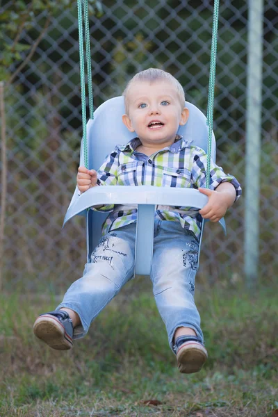 Le petit garçon sur une balançoire — Photo