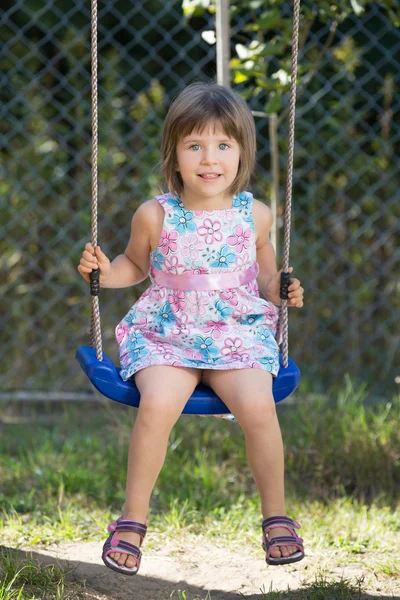 Ridendo bambina su un'altalena — Foto Stock