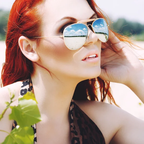 Belle femme aux cheveux roux en lunettes de soleil — Photo