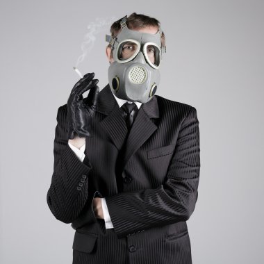 bir sigara ile gaz maskeli adam