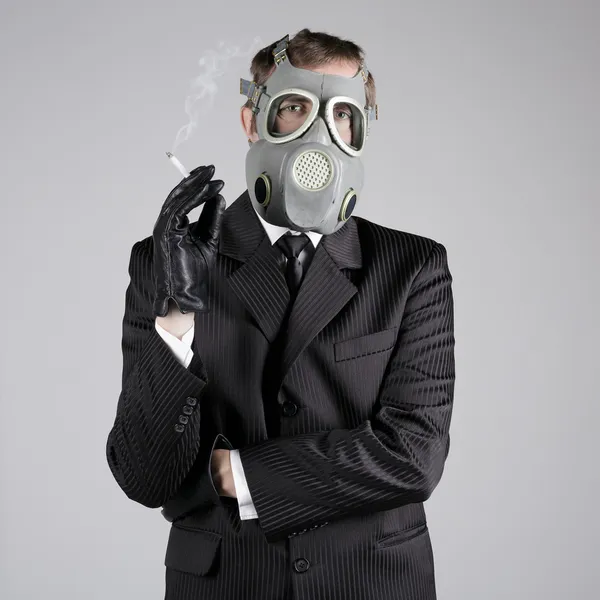 Man in a gas mask with a cigarette — Stock Photo, Image