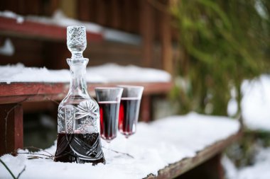 Decanter and wineglasses of red wine outdoors clipart