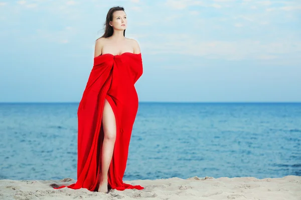 Beautiful woman in red on the beach — Stock Photo, Image