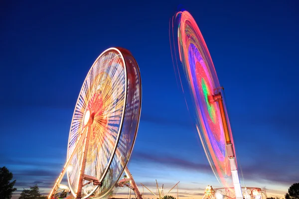 Parque de diversões ao entardecer - Roda gigante em movimento — Fotografia de Stock