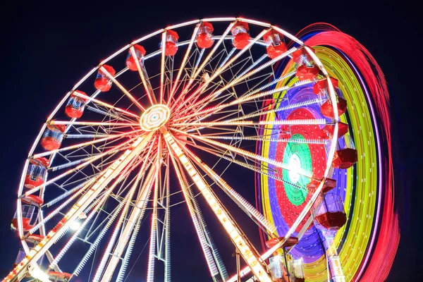 Pretpark in de schemering - reuzenrad in beweging — Stockfoto