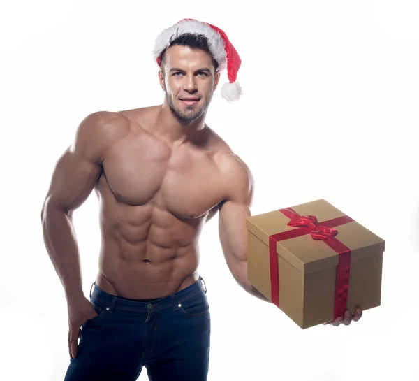 Gespierd, sexy santa claus met cadeau — Stockfoto