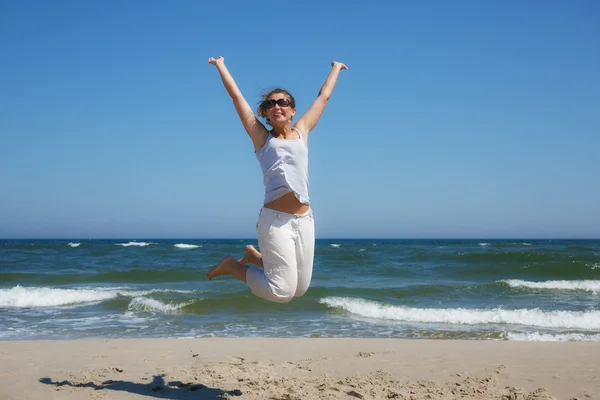 Femme dans un tir de saut sur la plage de la mer Baltique en été — Photo