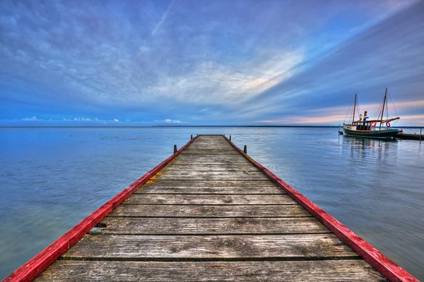 Refugio de madera en la bahía de Puck y barco — Foto de Stock