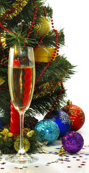 Festive image of a glass of champagne, candles and Christmas tree on a white background — Stock Photo, Image