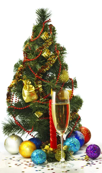 Bella immagine festiva di un bicchiere di champagne, candele e albero di Natale su uno sfondo bianco — Foto Stock