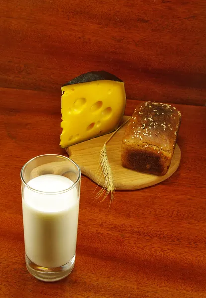 Bild eines Glases Milch, Brot auf dem Brett, Spieß und Käse auf dem Tisch — Stockfoto