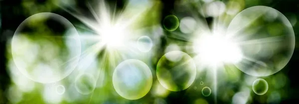 放射状に変化する光線と緑のぼやけた抽象的な背景の上に幻想的な浮遊ボールと明るい輝きの抽象的なイメージ — ストック写真