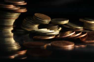 A vertical shot of a pile of golden coins and copper coins.