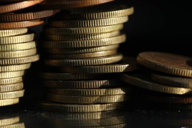 A vertical shot of a pile of golden coins and copper coins.