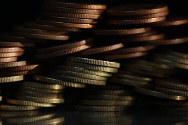 A vertical shot of a pile of golden coins and copper coins.