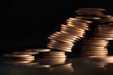 A vertical shot of a pile of golden coins and copper coins.