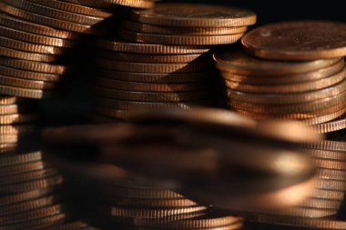 A vertical shot of a pile of golden coins and copper coins.