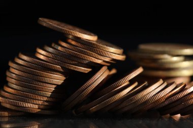 A vertical shot of a pile of golden coins and copper coins.