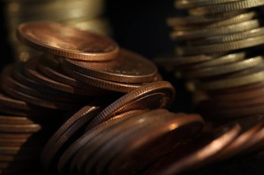 A vertical shot of a pile of golden coins and copper coins.