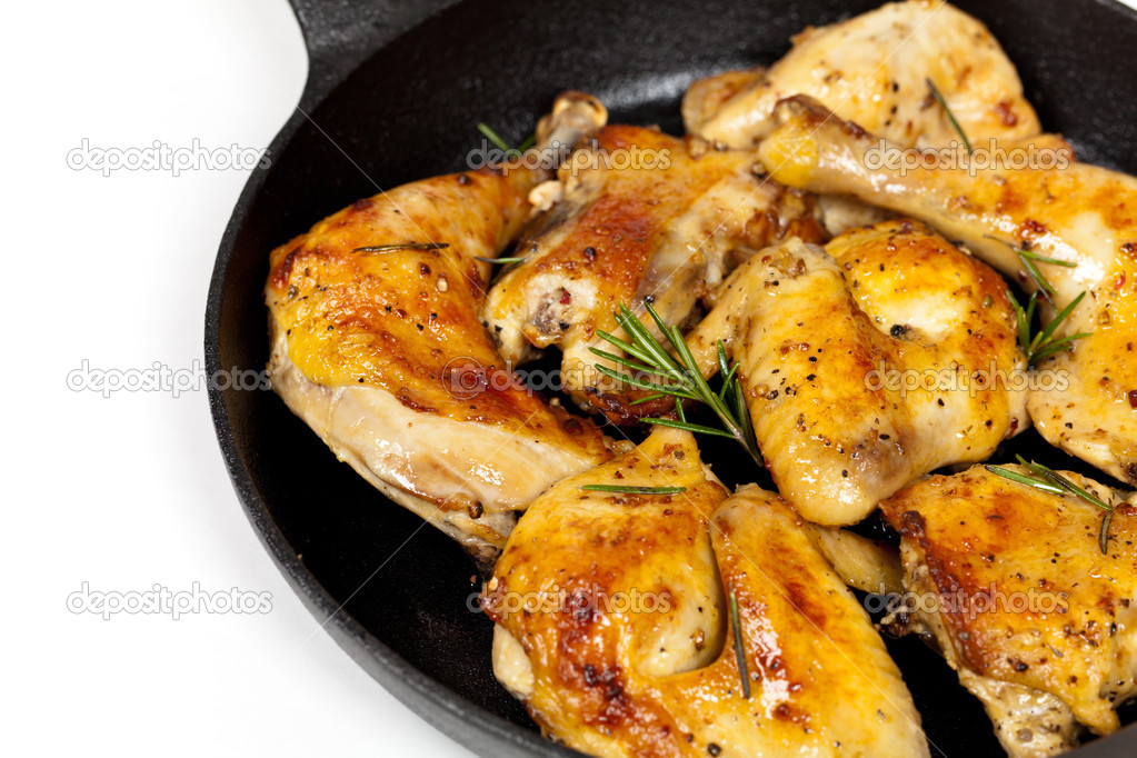 Frying pan with chicken, garlic and rosemary