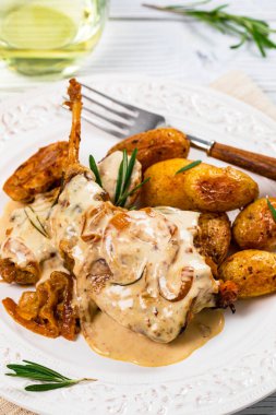 Ekşi Krema soslu Biberiyeli Tavşan eti ve Beyaz Tahta Arkaplanda Patates. Seçici odak.