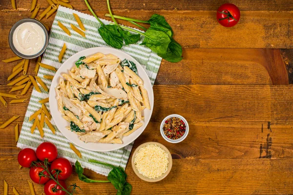 鸡阿尔弗雷多Parmesan Penne Pasta与菠菜在木制背景图 有选择的重点 — 图库照片