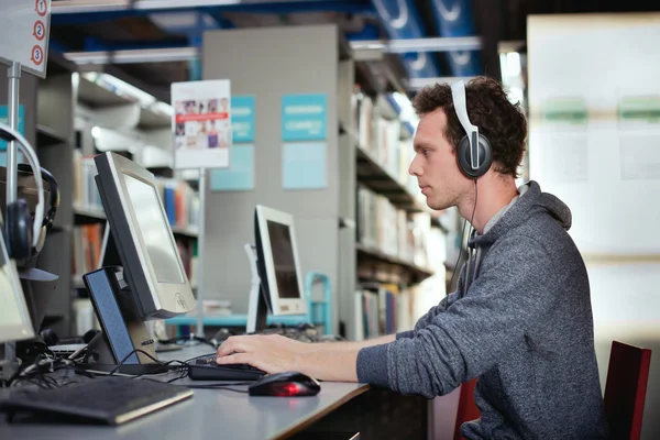 Student werkt op de computer in de bibliotheek — Stockfoto