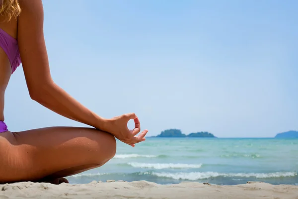 Mujer en posición de loto meditando en la playa — Foto de Stock