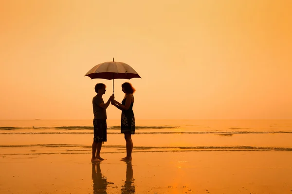 Silhouetten von Paar mit Regenschirm — Stockfoto