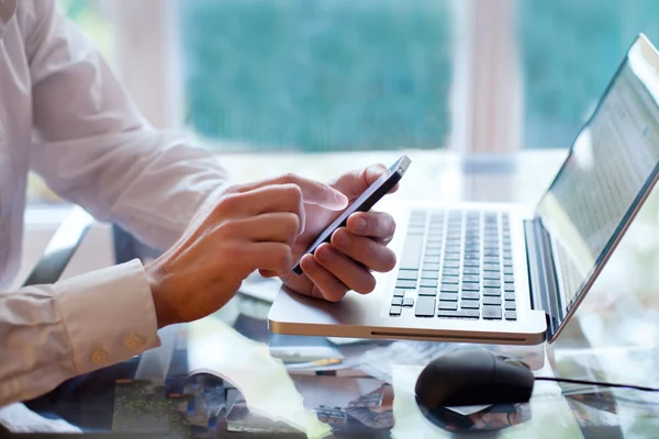 Man met behulp van een mobiele en laptop — Stockfoto