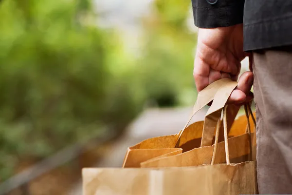 Erkek eli ile alışveriş torbaları — Stok fotoğraf