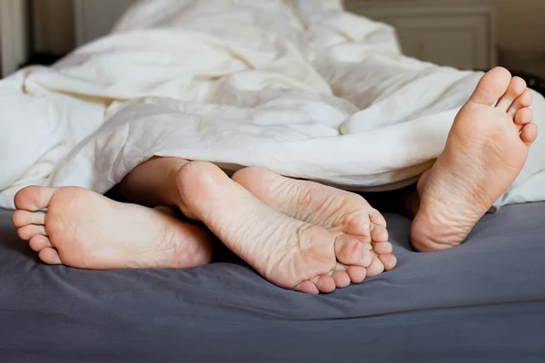 Fötter i sängen — ストック写真
