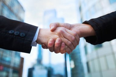 Two businessman shaking hands greeting each other clipart