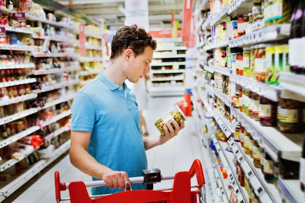 Kille väljer matvaror i stormarknad — Stockfoto