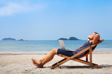 Man with laptop on the beach