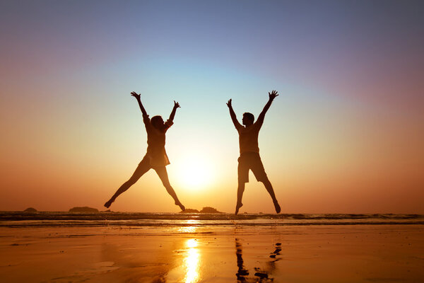 Couple jumping on  the beach