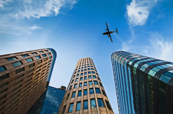 Ofis binalarının üzerinde uçak. — Stok fotoğraf
