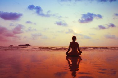 Kumsalda meditasyon yapan bir kadın.