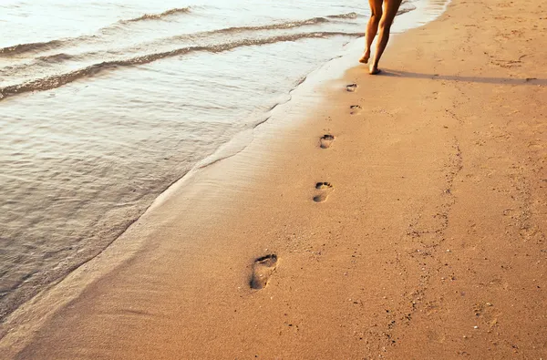 Pés femininos em uma praia de areia — Fotografia de Stock