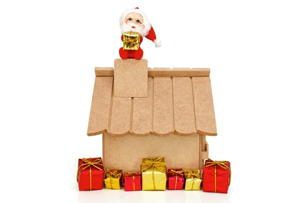 Santa Claus on roof holding a gift — Stock Photo, Image