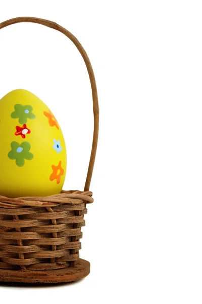 Yellow Easter egg into a basket — Stock Photo, Image