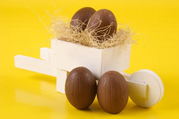Quatro ovos de Páscoa e carrinho de mão — Fotografia de Stock