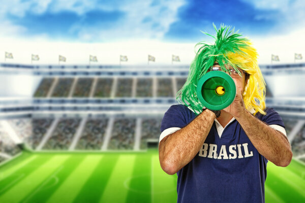 Бразильский болельщик празднует гол
