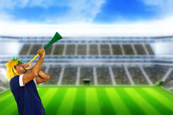 Brazilian fan at stadium playing vuvuzela — Stock Photo, Image