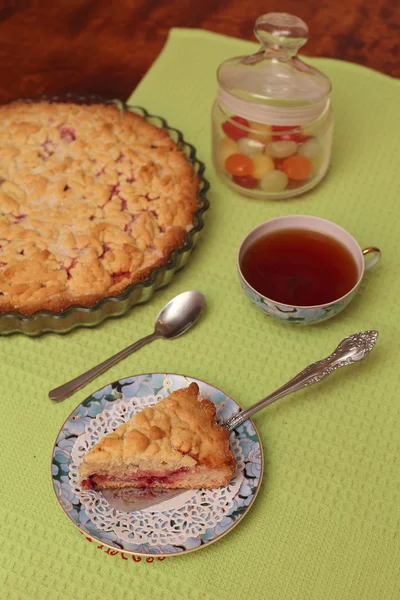Red berry pie on a wooden table with tea — Stock Photo, Image