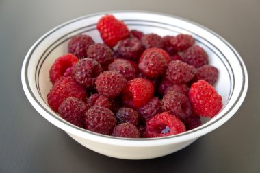 Ahududu siyah ahşap masa portre üzerinde bir kase