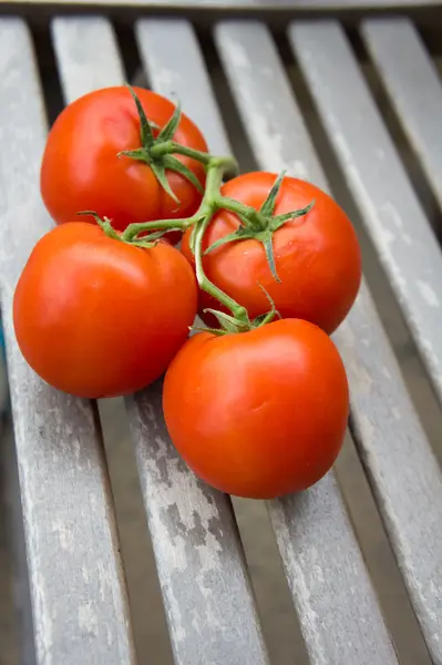 A bunch of tomatoes on a wooden table — Stock Photo, Image