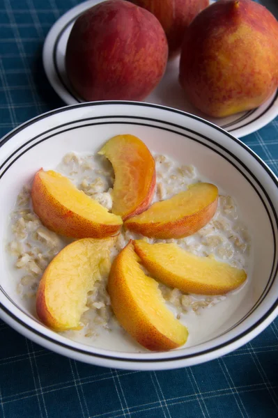 Peaches oatmeal on a blue tablecloth served — Stock Photo, Image