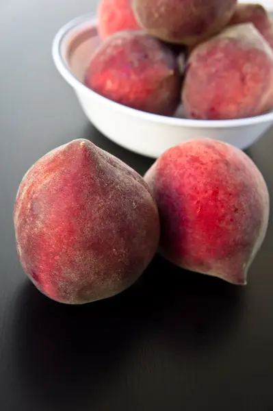 Peaches on a black wooden table — Stock Photo, Image