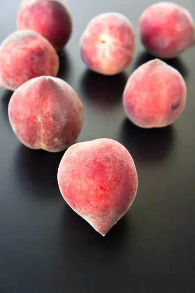 Peaches on a black wooden table — Stock Photo, Image